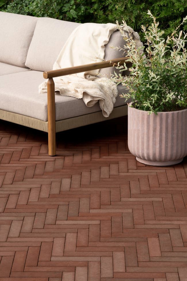Close up of the Westmount paver in merlot red installed in a herringbone pattern.